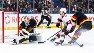 Ottawa Senators' Josh Norris (9) scores on Vancouver Canucks goaltender Kevin Lankinen (32) as Brock Boeser (6) looks on during second period NHL hockey action in Vancouver on Saturday, December 21, 2024. (Ethan Cairns/CP)