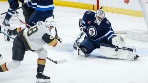 Connor Hellebuyck (37) saves the backhander from Vegas Golden Knights' Tomas Hertl (48) during first period action in Winnipeg, Thursday, Dec. 12, 2024. (John Woods/CP)