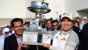 Derek Sprague, President of the PGA of America, applauds as Inbee Park of South Korea raises the PGA Women's championship trophy after winning the KPMG Women's PGA golf championship at Westchester Country Club on Sunday, June 14, 2015, in Harrison, N.Y. This is Park's third consecutive win of the Women's PGA championship. (AP Photo/Kathy Kmonicek)