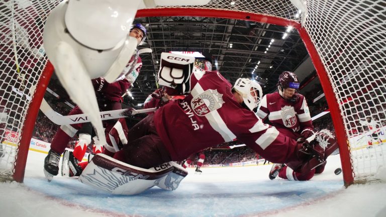 Latvia goaltender Linards Feldbergs (29) turns to make a save against Canada with help from Martins Klaucans (right) during first period IIHF World Junior Hockey Championship preliminary round action in Ottawa on Friday, Dec. 27, 2024. (Sean Kilpatrick/CP)