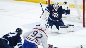 Winnipeg Jets goaltender Connor Hellebuyck (37) saves the shot from Montreal Canadiens' Patrik Laine (92) during first period NHL action in Winnipeg, Saturday, Dec. 14, 2024. (John Woods/CP)