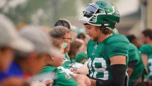 Saskatchewan Roughriders defensive back Jayden Dalke interacts with fan after a spring training scrimmage in Saskatoon, Sask., on Saturday, May 20, 2023. (THE CANADIAN PRESS/Heywood Yu)