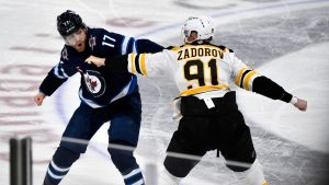 Boston Bruins' Nikita Zadorov (91) fights with Winnipeg Jets' Adam Lowry (17) during the third period of their NHL hockey game in Winnipeg, Tuesday December 10, 2024. (Fred Greenslade/CP)