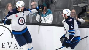 Winnipeg Jets centre Adam Lowry, left, celebrates with teammate Dylan DeMelo (2) after scoring a goal against the San Jose Sharks during the third period of an NHL hockey game in San Jose, Calif., Tuesday, Dec. 17, 2024. Winnipeg won 4-3. (Tony Avelar/AP)