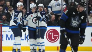 Winnipeg Jets left wing Kyle Connor (81) celebrates with teammates Gabriel Vilardi (13) and Mark Scheifele (55) after scoring as Toronto Maple Leafs centre John Tavares (91) skates away during second period NHL action in Toronto on Monday, Dec. 23, 2024. (Nathan Denette/CP)