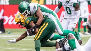 Saskatchewan Roughriders' Justin Herdman-Reed (48) tackles Edmonton Elks' Malik Flowers (88) during first half CFL action in Edmonton on Saturday, June 8, 2024. (Jason Franson/CP)