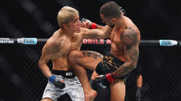 Alexandre Pantoja, right, knees Kai Asakura in a UFC 310 mixed martial arts flyweight title bout at T-Mobile Arena, Saturday, Dec. 7, 2024, in Las Vegas. (Wade Vandervort/Las Vegas Sun via AP)