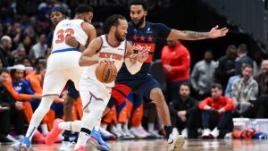 New York Knicks guard Jalen Brunson handles the ball against Washington Wizards forward Justin Champagnie during the first half of an NBA basketball game, Saturday, Dec. 28, 2024, in Washington. (AP Photo/Terrance Williams)