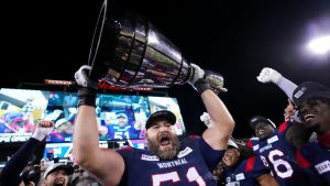 Montreal Alouettes guard Kristian Matte (51) hoists the Grey Cup as the Alouettes celebrate defeating the Winnipeg Blue Bombers in the 110th CFL Grey Cup. (Nathan Denette/CP)