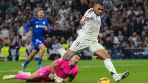 Real Madrid's Kylian Mbappe kicks the ball in an attempt to score during the Spanish La Liga soccer match between Real Madrid and Getafe at the Santiago Bernabeu Stadium in Madrid, Spain, Sunday, Dec. 1, 2024. (AP/Bernat Armangue)