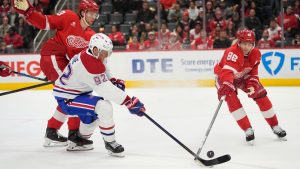 Montreal Canadiens right wing Patrik Laine (92) and Detroit Red Wings right wing Patrick Kane (88) reach for the puck during the first period of an NHL hockey game, Friday, Dec. 20, 2024, in Detroit. (AP Photo/Carlos Osorio)