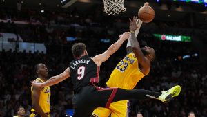 Miami Heat guard Pelle Larsson (9) fouls Los Angeles Lakers forward LeBron James (23) during the first half of an NBA basketball game, Wednesday, Dec. 4, 2024, in Miami. (AP Photo/Marta Lavandier)