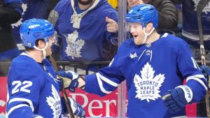 Toronto Maple Leafs centre Steven Lorentz (18) celebrates with teammate Jake McCabe (22) after scoring his team's second goal against New York Islanders during second period NHL hockey action in Toronto on Tuesday, December 31, 2024. (Chris Young/CP)