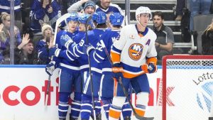 Toronto Maple Leafs forward David Kampf (left) is congratulated by teammates after scoring the Leafs' opening goal as New York Islanders forward Brock Nelson skates past during first-period NHL action in Toronto on Tuesday, Dec. 31, 2024. (Chris Young/CP)
