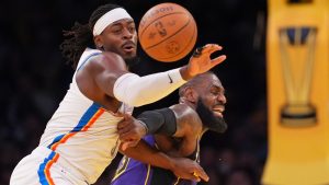 Oklahoma City Thunder guard Luguentz Dort, left, and Los Angeles Lakers forward LeBron James, right, go after the ball during the first half of an Emirates NBA Cup basketball game, Friday, Nov. 29, 2024, in Los Angeles. (AP Photo/Mark J. Terrill)