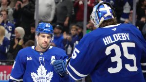 Toronto Maple Leafs centre John Tavares (91) celebrates his third goal of the game with teammate goaltender Dennis Hildeby (35) during late third period NHL hockey action against the Buffalo Sabres after they pulled their goalie for an extra skater in Toronto, Sunday, Dec. 15, 2024. (Frank Gunn/CP)