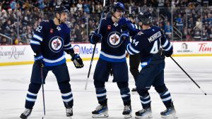 Winnipeg Jets' Mark Scheifele (55) celebrates his goal against the Boston Bruins with Nino Niederreiter (62) and Josh Morrissey (44) during the second period of their NHL game in Winnipeg, Tuesday December 10, 2024. (THE CANADIAN PRESS/Fred Greenslade)