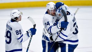 Toronto Maple Leafs goalie Matt Murray, right, celebrates with center Bobby McMann (74) and left wing Nicholas Robertson (89) after their win in an NHL hockey game against the Buffalo Sabres in Buffalo, N.Y., Friday, Dec. 20, 2024. Toronto won 6-3. (Adrian Kraus/AP)