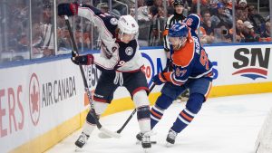 Columbus Blue Jackets' Kent Johnson (91) and Edmonton Oilers' Connor McDavid (97) battle for the puck during first period NHL action in Edmonton on Thursday, December 5, 2024. (Jason Franson/CP)