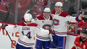 Montreal Canadiens right wing Cole Caufield (13) celebrates with Nick Suzuki (14) and Juraj Slafkovsky (20) after scoring a goal during the third period of an NHL hockey game against the Florida Panthers. (Lynne Sladky/AP)