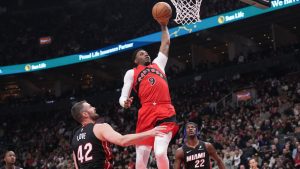 Toronto Raptors' RJ Barrett (9) scores as Miami Heat's Kevin Love (42) and Jimmy Butler (22) look on during first half NBA basketball action in Toronto, Sunday, Dec. 1, 2024. (Chris Young/CP)