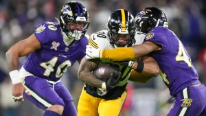 Pittsburgh Steelers running back Jaylen Warren (30) runs with the ball as Baltimore Ravens cornerback Marlon Humphrey, right, and linebacker Malik Harrison try to stop him during the first half of an NFL football game, Saturday, Dec. 21, 2024, in Baltimore. (Stephanie Scarbrough/AP)