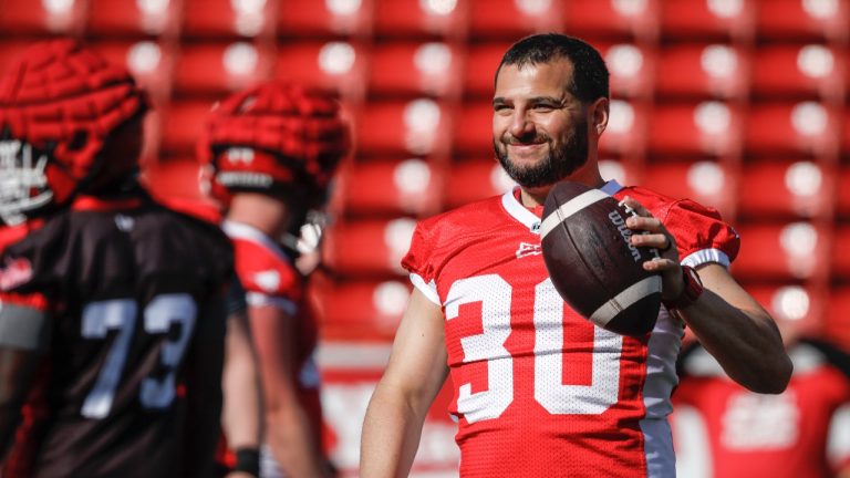 Calgary Stampeders kicker Rene Paredes smiles at teammate as he passes the ball during opening day of training camp in Calgary on May 12, 2024. (THE CANADIAN PRESS/Jeff McIntosh)