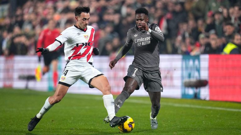 Rayo's Pedro Diaz, left, challenges for the ball with Real Madrid's Rodrygo during the Spanish La Liga soccer match between Rayo Vallecano and Real Madrid at the Vallecas stadium in Madrid, Spain, Saturday, Dec. 14, 2024. (AP Photo/Manu Fernandez)