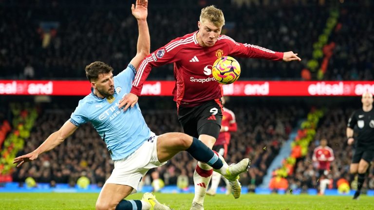 Manchester City's Ruben Dias, left, challenges for the ball with Manchester United's Rasmus Hojlund during the English Premier League soccer match between Manchester City and Manchester United at the Etihad Stadium in Manchester, Sunday, Dec. 15, 2024. (Dave Thompson/AP)