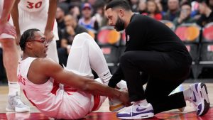 Toronto Raptors forward Scottie Barnes (4) is tended to by a team trainer after getting hurt during second half NBA basketball action against the New York Knicks, in Toronto, Monday, Dec. 9, 2024. THE CANADIAN PRESS/Nathan Denette