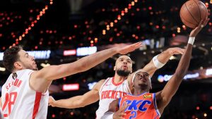 Oklahoma City Thunder guard Shai Gilgeous-Alexander (2) shoots against Houston Rockets center Alperen Sengun (28) and forward Dillon Brooks, back right, during the first half of a semifinal game in the NBA Cup basketball tournament. (Ian Maule/AP)