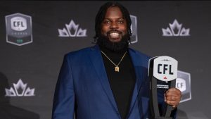 Most outstanding offensive linesman Stanley Bryant of the Winnipeg Blue Bombers, holds up his trophy during the CFL Awards in Regina, Thursday, Nov. 17, 2022. Bryant will return for a 14th CFL season and ninth with Winnipeg after signing a one-year contact extension with the Blue Bombers. (THE CANADIAN PRESS/Paul Chiasson)