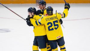 Sweden forward Otto Stenberg (25) and teammate Rasmus Bergqvist (2) celebrate Axel Sandin-Pellikka's (4) hat-trick goal during third period IIHF World Junior Hockey Championship preliminary round action against Slovakia, in Ottawa, Thursday, Dec. 26, 2024. (Spencer Colby/CP)