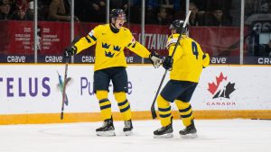 Sweden defenceman Rasmus Bergqvist (2) celebrates his goal with teammate Axel Sandin-Pellikka (4) during second period IIHF World Junior Hockey Championship preliminary round action against Slovakia, in Ottawa, Thursday, Dec. 26, 2024. (Spencer Colby/CP)