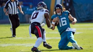 Jacksonville Jaguars quarterback Trevor Lawrence (16) begins to slide down as Houston Texans linebacker Azeez Al-Shaair (0) charges forward during the first half of an NFL football game, Sunday, Dec. 1, 2024, in Jacksonville, Fla. (John Raoux/AP)