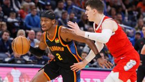 Oklahoma City Thunder guard Shai Gilgeous-Alexander (2) drives past Memphis Grizzlies forward Jake LaRavia, right, during the first half of an NBA basketball game Sunday, Dec. 29, 2024, in Oklahoma City. (AP Photo/Nate Billings)