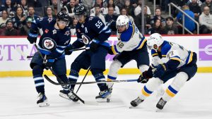 Winnipeg Jets' Kyle Connor (81) and Mark Scheifele (55) battle for the puck with St. Louis Blues' Radek Faksa (12) and Pierre-Olivier Joseph (77) during the second period of their NHL hockey game in Winnipeg, Tuesday December 3, 2024. (Fred Greenslade/CP)