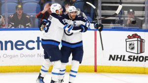 Winnipeg Jets center Adam Lowry (17) celebrates his game winning goal with forward Gabriel Vilardi (13) following the overtime period of an NHL hockey game against the Buffalo Sabres Thursday, Dec. 5, 2024, in Buffalo, N.Y. (Jeffrey T. Barnes/AP)