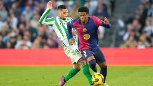 Barcelona's Alejandro Balde, right, challenges for the ball with Betis' Chimy Avila during a Spanish La Liga soccer match between Betis and Barcelona at the Benito Villamarin stadium in Seville, Spain, Saturday, Dec. 7, 2024. (Jose Breton/AP)