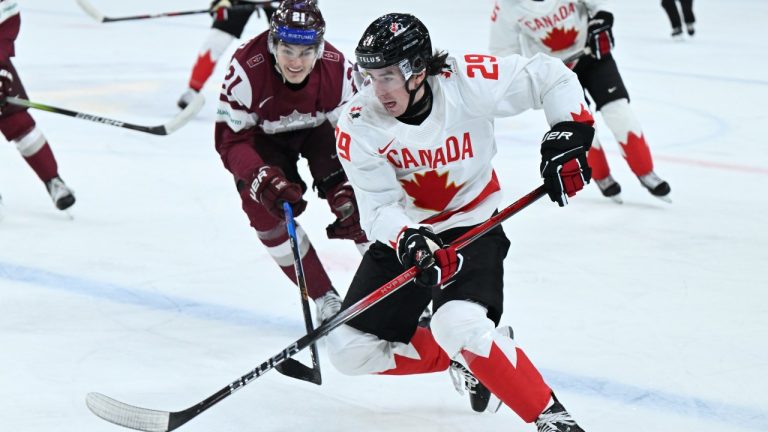 Latvia's Rauls Ozollapa, left, and Canada's Brayden Yager in action during the IIHF World Junior Championship group A ice hockey match between Latvia and Canada at Scandinavium in Gothenburg, Sweden, Wednesday, Dec. 27, 2023. (Bjorn Larsson Rosvall/TT News Agency via AP)