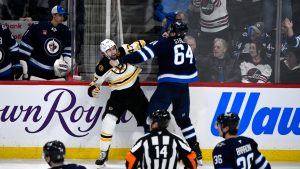 Boston Bruins' Mark Kastelic (47) fights with Winnipeg Jets' Logan Stanley (64) during the third period of their NHL hockey game in Winnipeg, Tuesday December 10, 2024. (Fred Greenslade/CP)