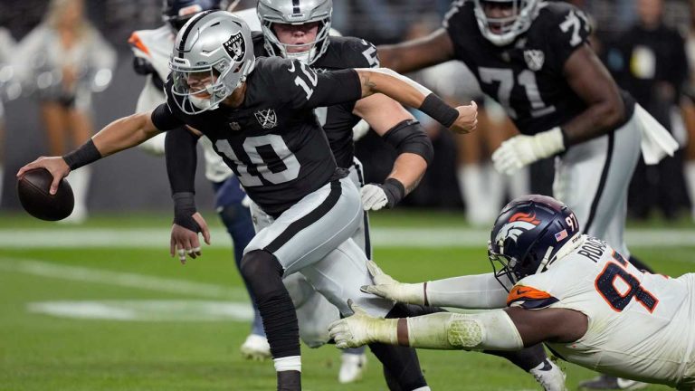 Las Vegas Raiders quarterback Desmond Ridder (10) is pressured by Denver Broncos defensive tackle Malcolm Roach (97) during the second half of an NFL football game. (John Locher/AP)