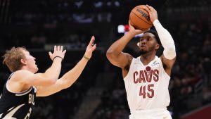 Cleveland Cavaliers guard Donovan Mitchell (45) shoots over Milwaukee Bucks guard AJ Green, left, in the first half of an NBA basketball game, Friday, Dec. 20, 2024, in Cleveland. (Sue Ogrocki/AP)