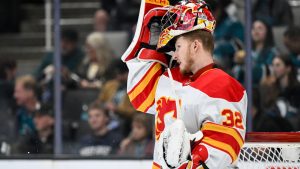 Calgary Flames goaltender Dustin Wolf stands on the ice during a break in play against the San Jose Sharks during the first period of an NHL hockey game Saturday, Dec. 28, 2024, in San Jose, Calif. (Eakin Howard/AP)