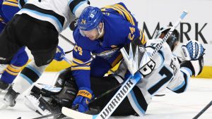 Buffalo Sabres centre Dylan Cozens (24) and Utah goaltender Karel Vejmelka (70) collide during the first period of an NHL hockey game Saturday, Dec. 7, 2024, in Buffalo, N.Y. (Jeffrey T. Barnes/AP)