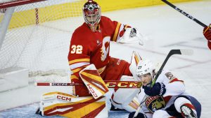 Florida Panthers' Eetu Luostarinen, right, crashes into Calgary Flames goalie Dustin Wolf during second period NHL hockey action in Calgary, Alta., Saturday, Dec. 14, 2024. (Jeff McIntosh/CP)