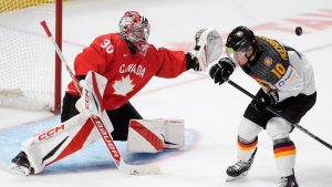 Germany forward Timo Ruckdaschel (10) attempts to screen Canada goaltender Carter George as he reaches for the puck during third period IIHF World Junior Hockey Championship tournament action in Ottawa, Sunday, Dec. 29, 2024. (Adrian Wyld/CP)