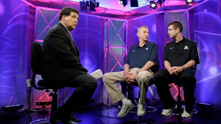 Greg Gumbel, left, watches as Connecticut head coach Jim Calhoun talks to Butler head coach Brad Stevens, right, prior to taping a television interview for the men's NCAA Final Four college basketball championship game Sunday, April 3, 2011, in Houston. (AP Photo)