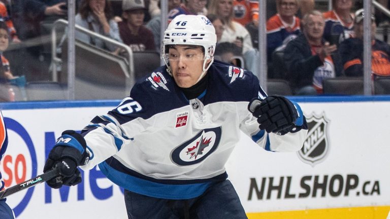 Winnipeg Jets' Kevin He (46) and Edmonton Oilers' William Nicholl (56) battle for the puck during second period NHL preseason action in Edmonton, Sunday, Sept. 22, 2024. (Jason Franson/CP)