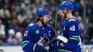 Vancouver Canucks' Quinn Hughes, left, talks to Elias Pettersson before a faceoff against the Edmonton Oilers during the third period in Game 7 of an NHL hockey Stanley Cup second-round playoff series, in Vancouver, on Monday, May 20, 2024. (Darryl Dyck/THE CANADIAN PRESS)